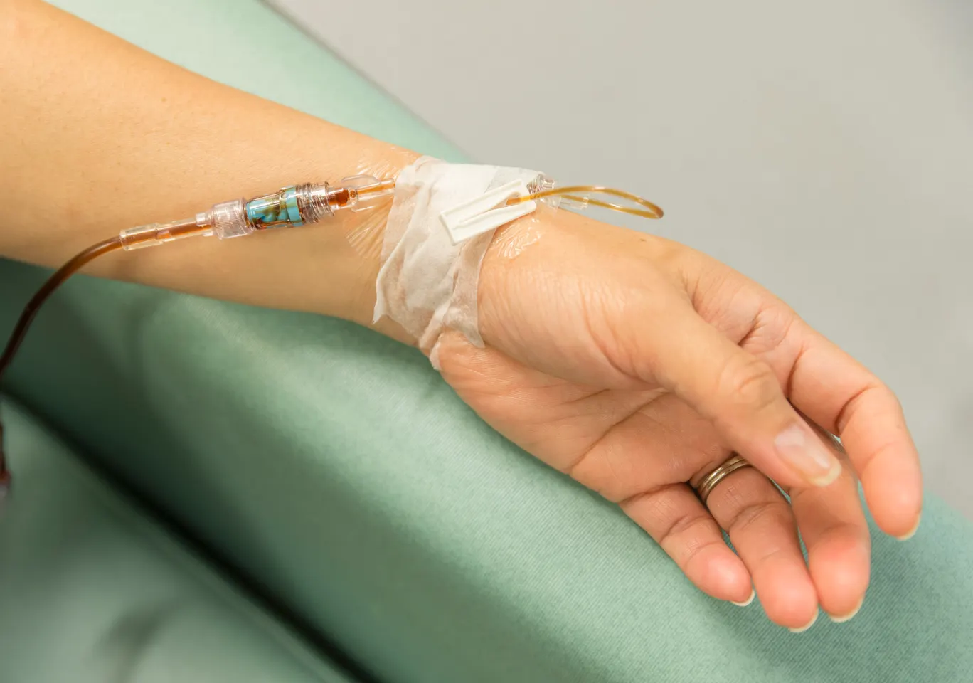 Kroplówki witaminowe Włoszczowa: dłoń z wenflonem i linią infuzyjną na podkładzie