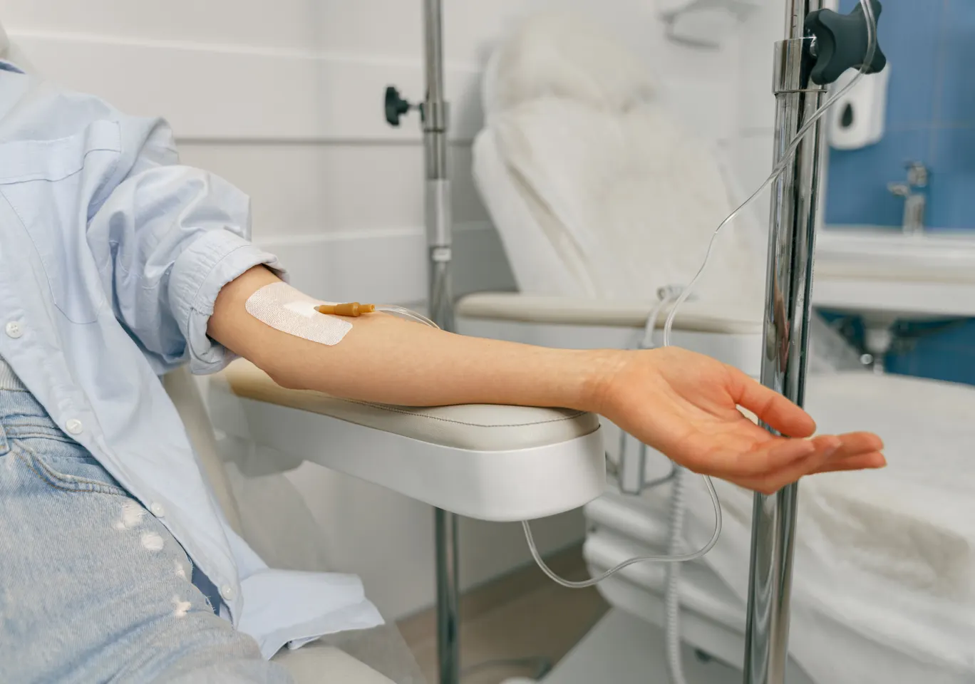Kroplówki witaminowe Staszów: przedramię z wenflonem i stojak infuzyjny obok